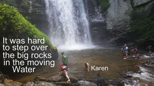 Karen Duquette having a hard time stepping over the big rocks in the water.